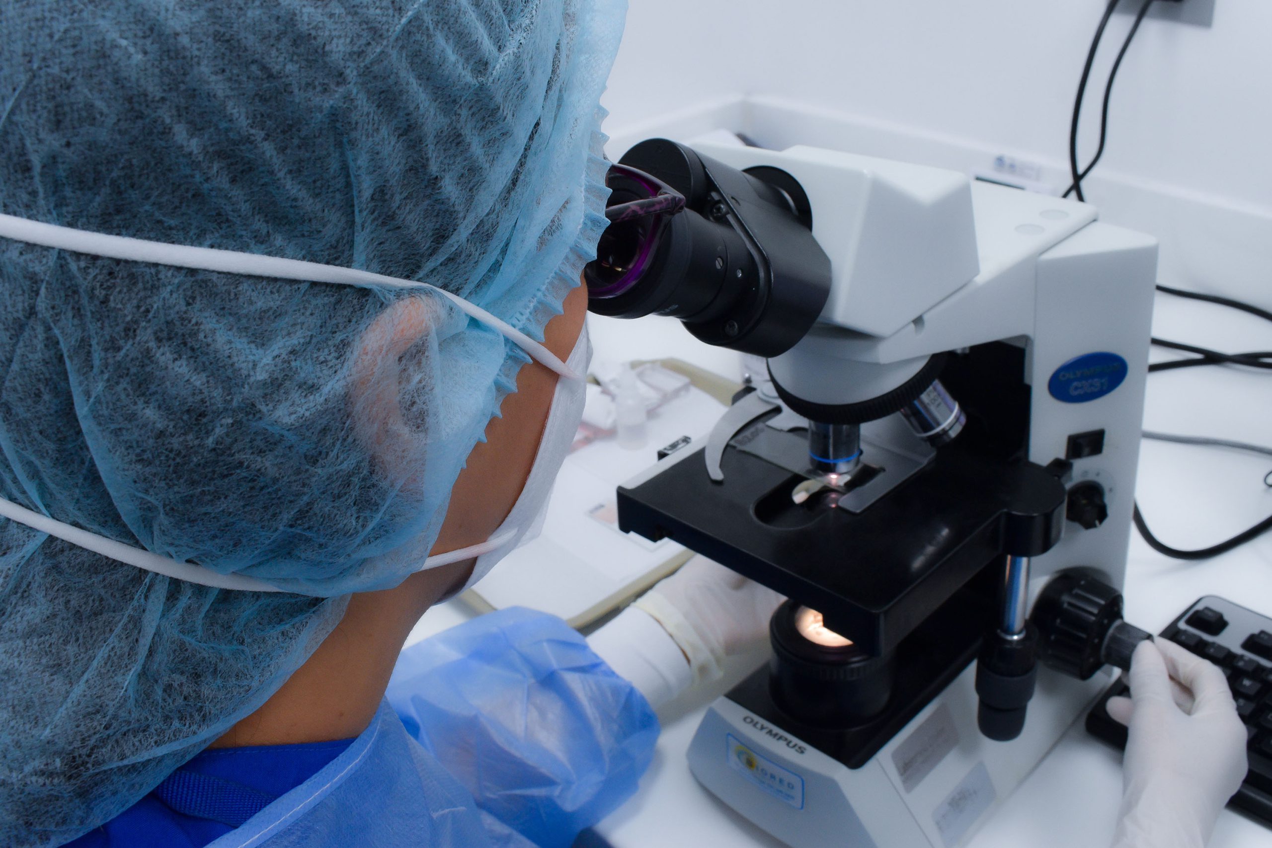 Profesional mirando a través del microscopio de laboratorio Clínico